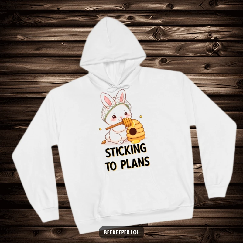 Funny Hoodie: A fluffy bunny in a netted hat, honey dipper in paw, curiously observing a beehive, offering warm and humorous casual wear for gentle souls.